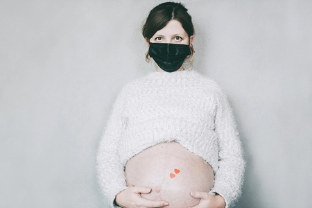 Young pregnant woman wearing a mask during covid 19 pandemic