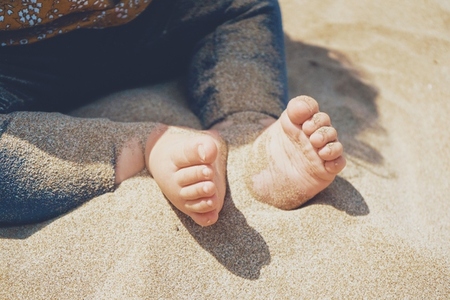 Close up of legs and feet of a baby sitting over the sun