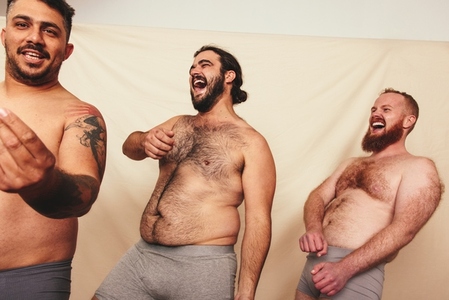 Group of shirtless men dancing in a studio