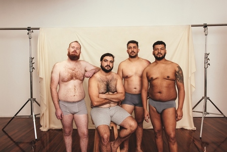 Group of shirtless men looking at the camera in a studio