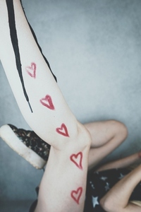Close up of a teen leg with red hearts drawing in it