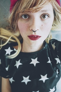 Young woman with a fresh and romantic look and a septum piercing