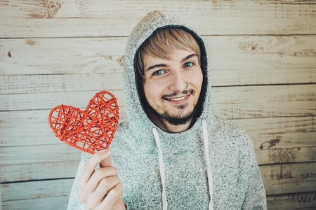 Young cool man holding a red heart