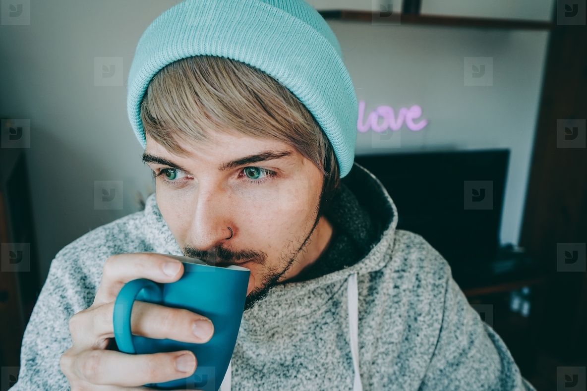 Young man enjoying a cup of coffee at home