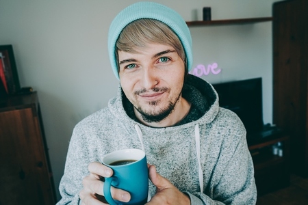 Young man enjoying a cup of coffee at home