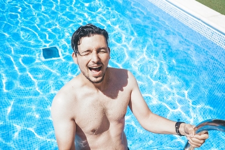 Young handsome man posing near a pool