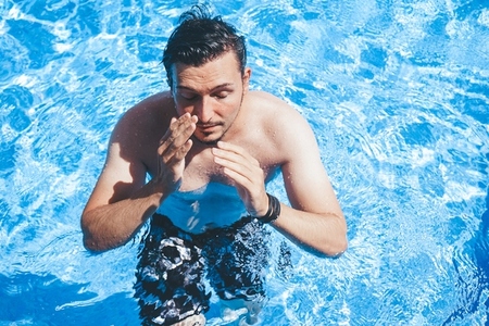 Young man enyoing the day at the swimming pool