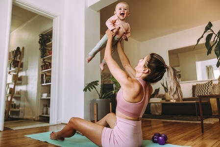 Mom lifting her adorable baby at home