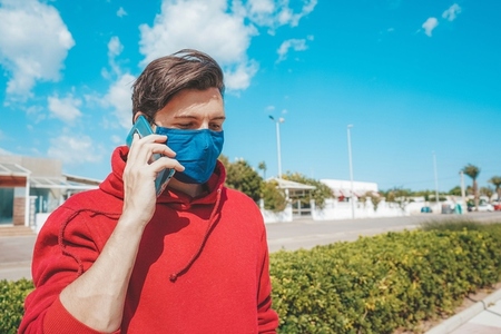 Men using his smartphone with a face mask in Spain