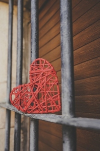 Lonely read heart over an iron fence