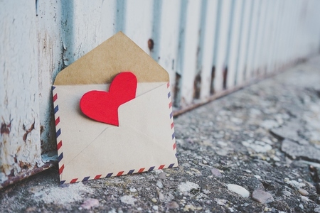 Little red hearts inside of an old envelope