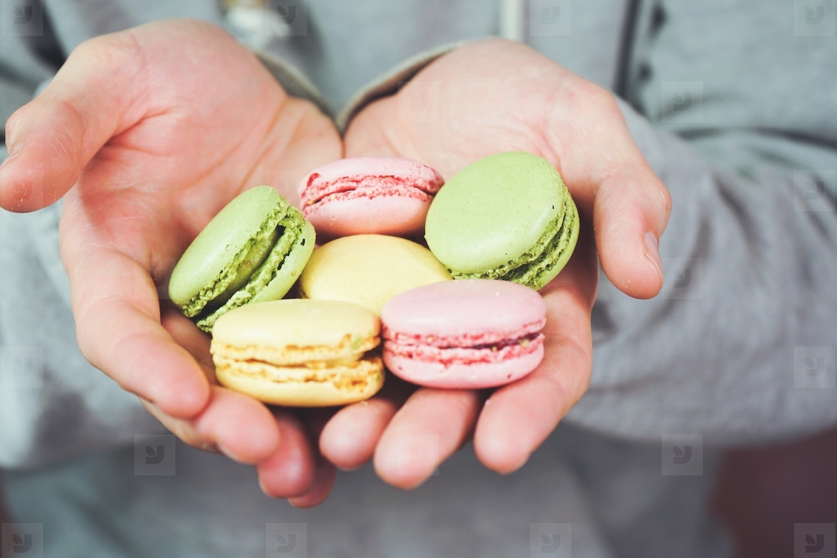 Man holding macarons in his hand