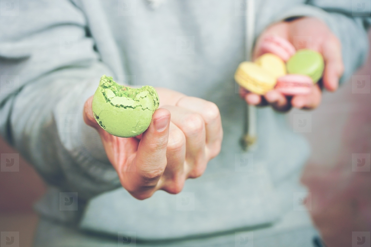 Man holding macaroins in his hands
