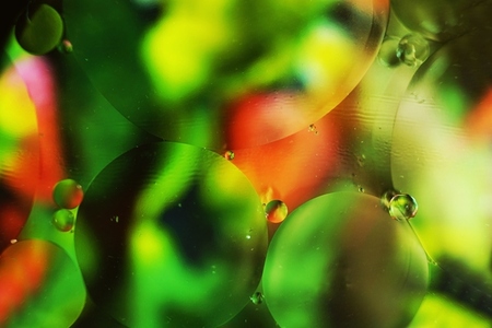 A beautiful and colorful macro of oil bubbles on water with a gr