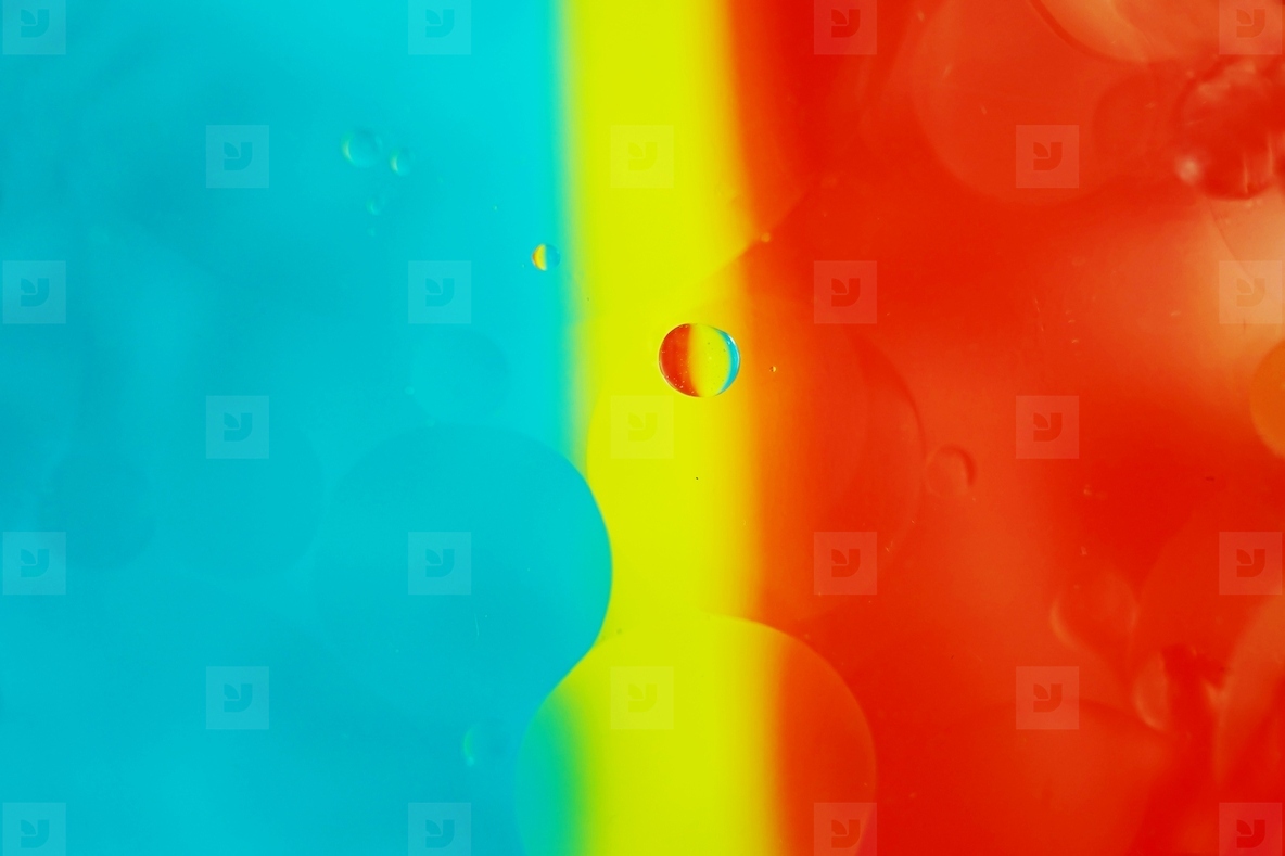 A beautiful and vibrant macro of oil bubbles on water with a yel