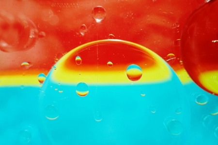 A beautiful and vibrant macro of oil bubbles on water with a yel