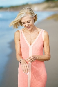 Mature woman on shore of a beach  Elderly female enjoying her retirement at a seaside retreat