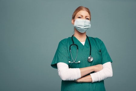 Frontline doctor wearing a mask and green scrubs