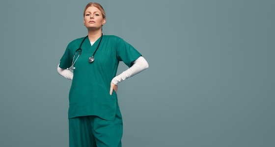 Young female doctor wearing green scrubs in a studio