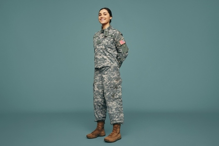 Happy female soldier smiling in a studio