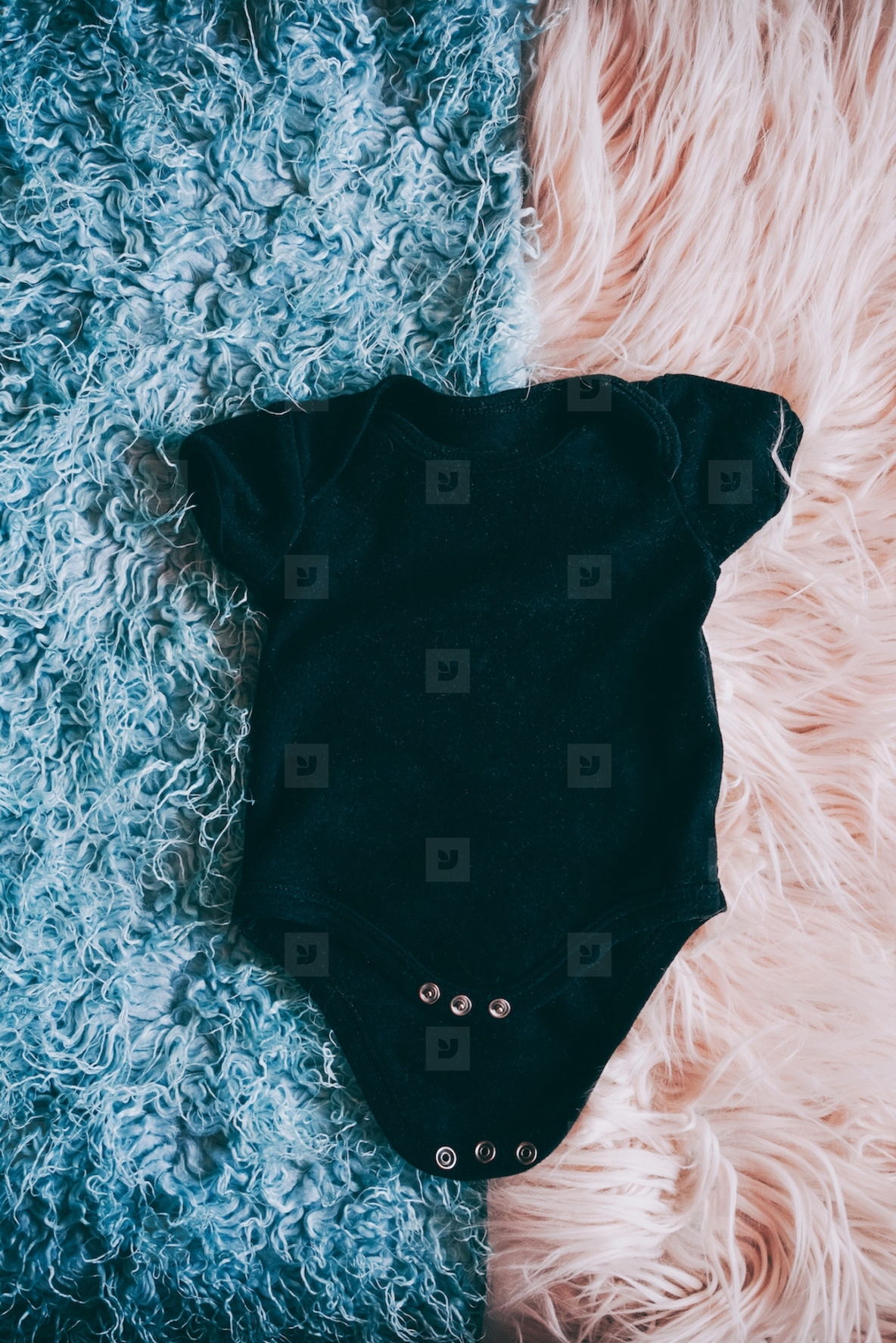 Black baby body agains a soft two colors background