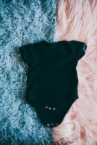 Black baby body agains a soft two colors background