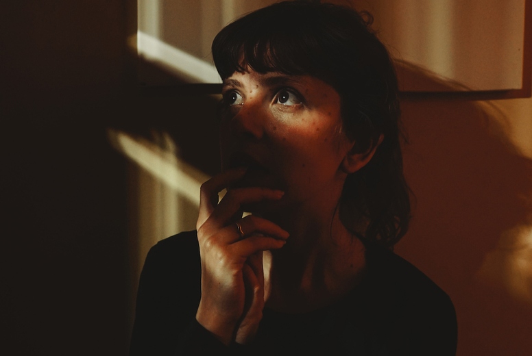 Artistic portrit of a young woman posing and crossed by ligths