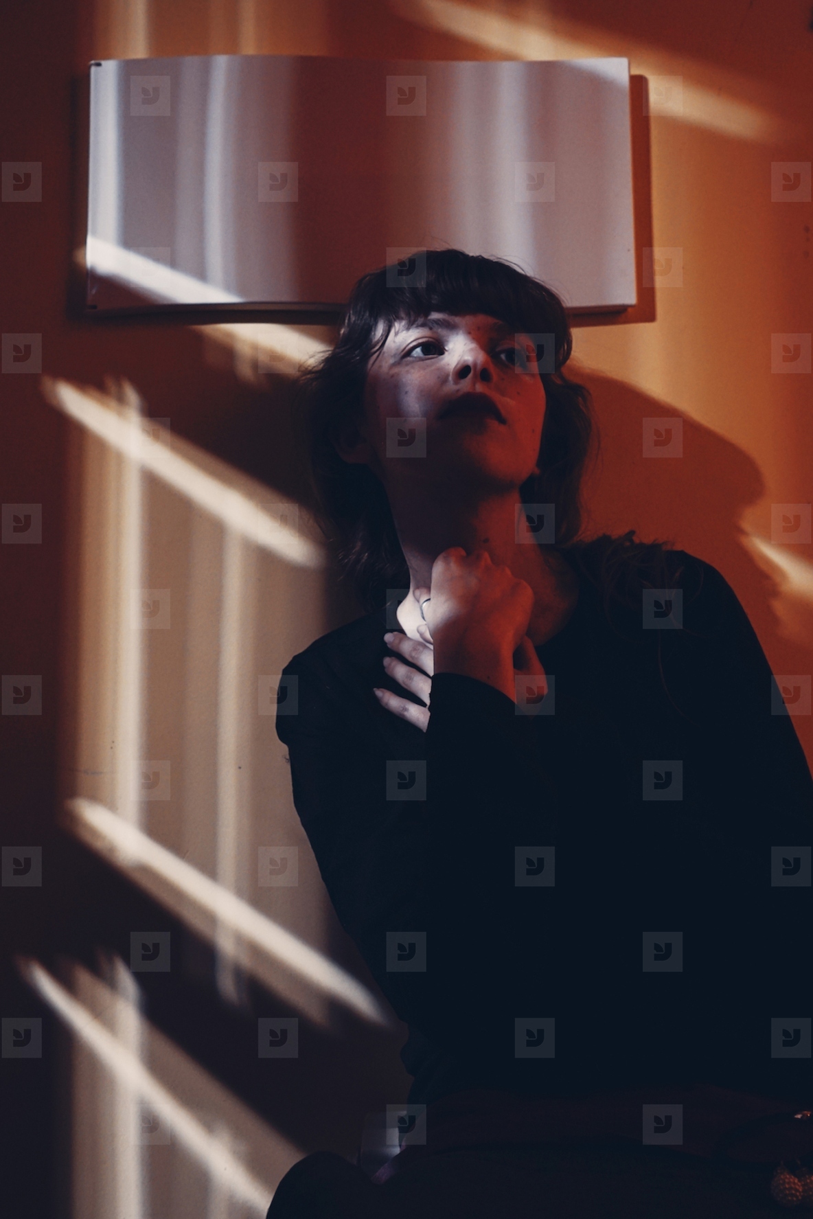 Artistic portrit of a young woman posing and crossed by ligths