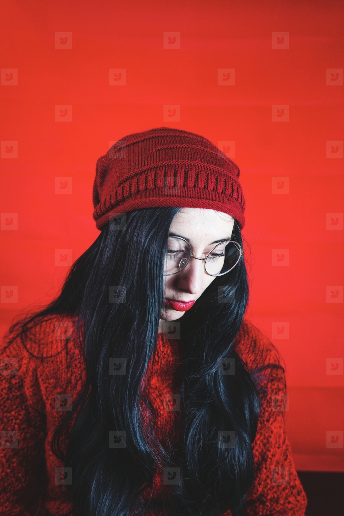 Portrait of a young brunette woman agains a red background