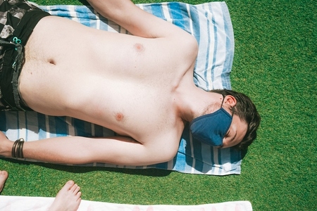 Young man in a swimming pool at summer wearing a face mask