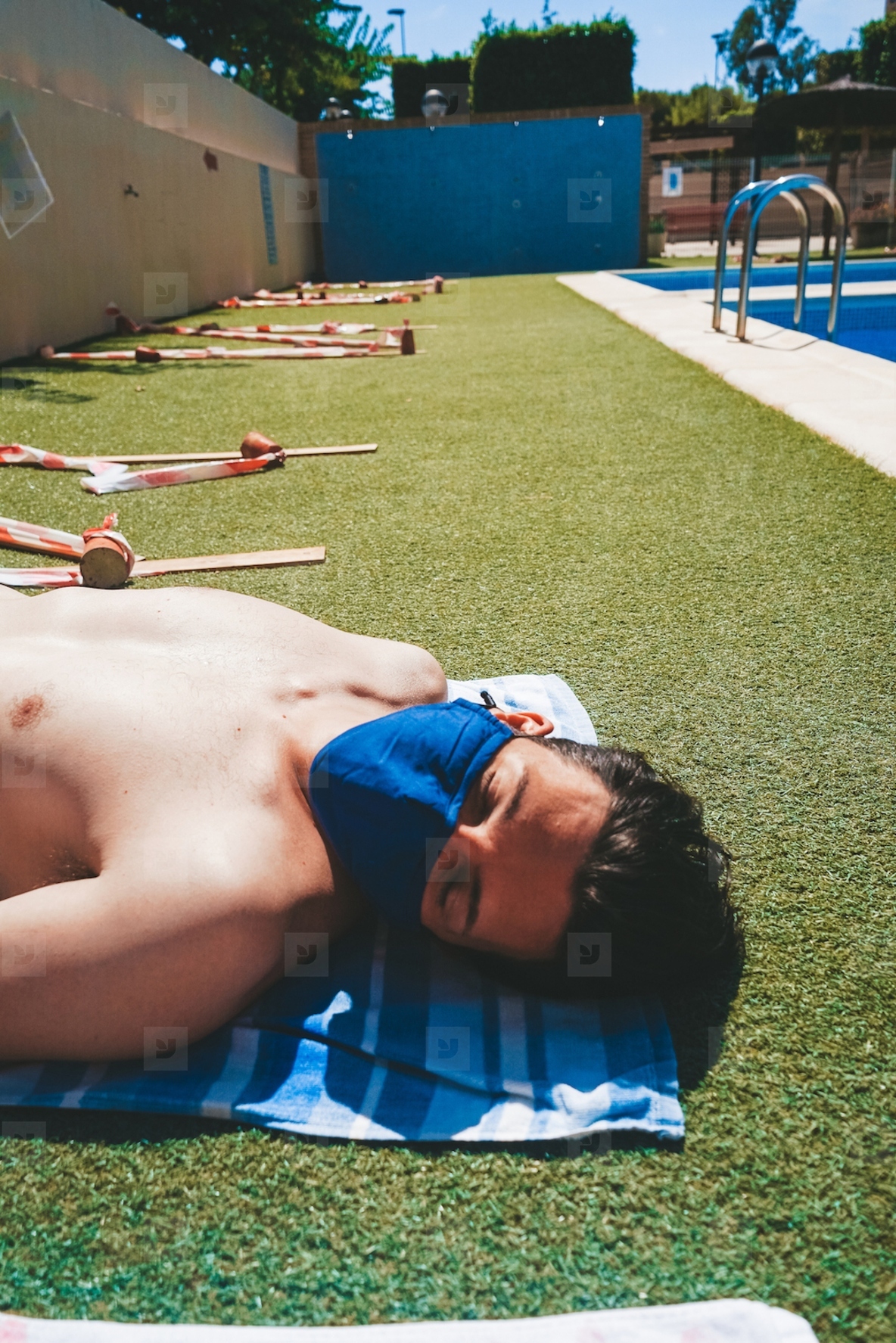 Young man in a swimming pool at summer wearing a face mask