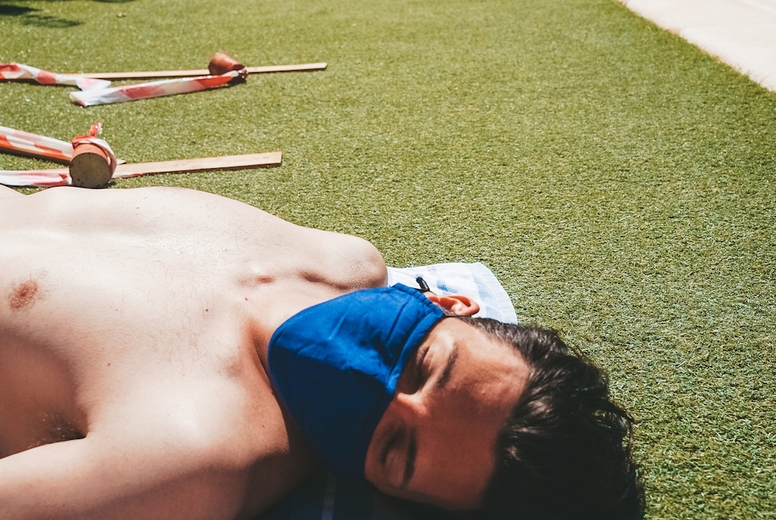 Young man in a swimming pool at summer wearing a face mask