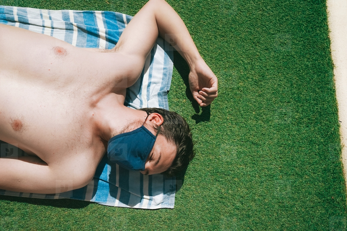 Young man in a swimming pool at summer wearing a face mask