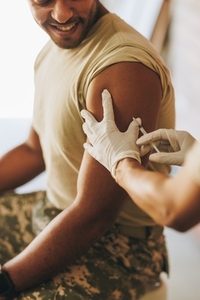 Young soldier receiving a vaccine in his arm
