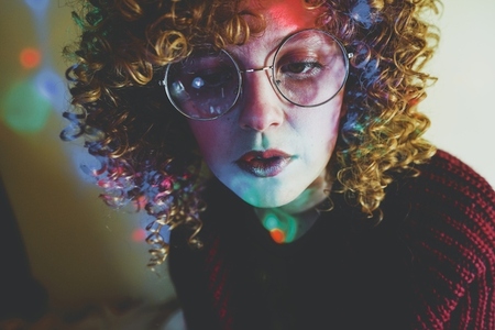 Young woman portrait illuminated by psychedelic lights