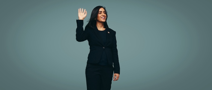 Congresswoman waving her hand against a studio background
