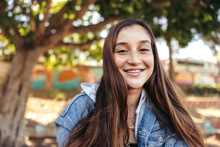 Smiling teenage girl looking at the camera outdoors