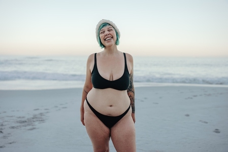 Carefree winter bather smiling with her eyes closed at the beach