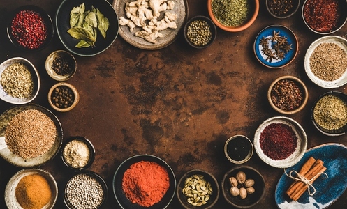 Flat lay of spices in bowls over rusty background  copy space