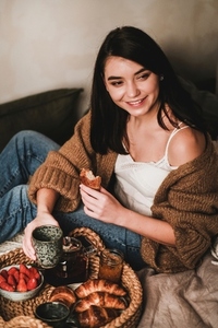 Young beautiful smiling brunette woman having breakfast in bed