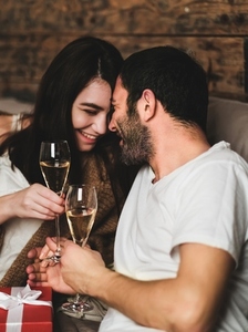 Young happy laughing couple celebrating with champagne