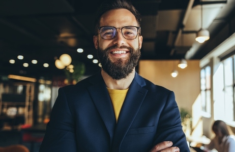 Cheerful businessman smiling at the camera in a co working space