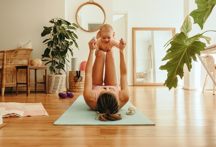 Yogi mom lifting her adorable baby with her legs