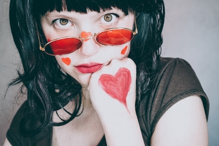 Cool portrait of a young woman wearing red glasses and full of r