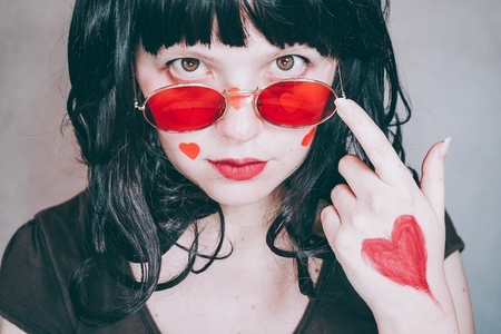 Cool portrait of a young woman wearing red glasses and full of r