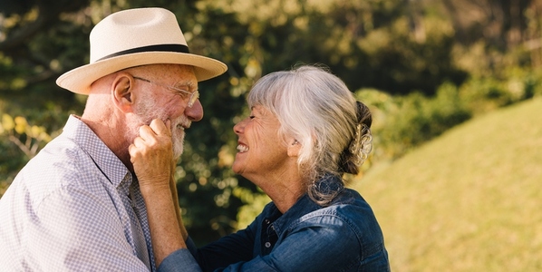 Elderly couple smiling at each other and expressing their love