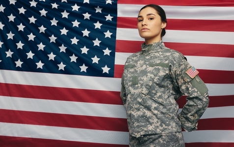 Courageous soldier standing against the United States flag