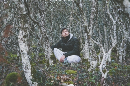 Young man alone in a huge forest
