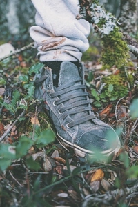 Detail of a foot with a sneaker walking in the forest