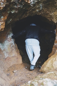 Young man get in into a dark cave